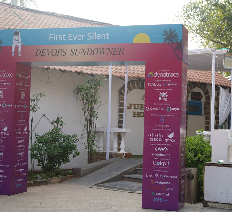 The entrance arch reading First Ever Silent DevOps Sundowner, partner logos down both columns