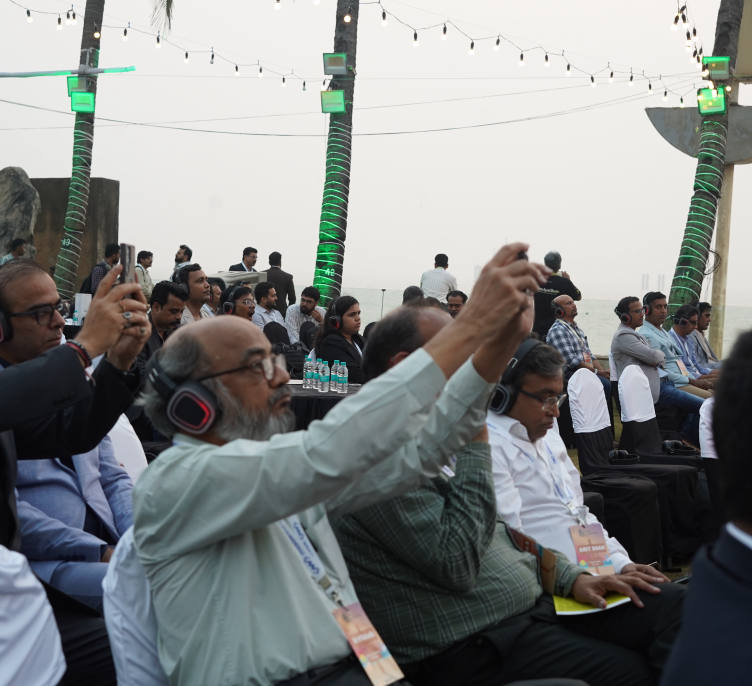 Attendees listening on the silent-conference headphones, the sea behind them