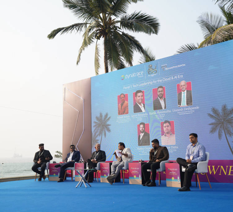 A panel in session on the open-air stage, the sea directly behind the set