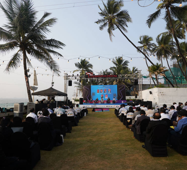 The room seated on the lawn facing the stage, the sea and the coastline beyond it